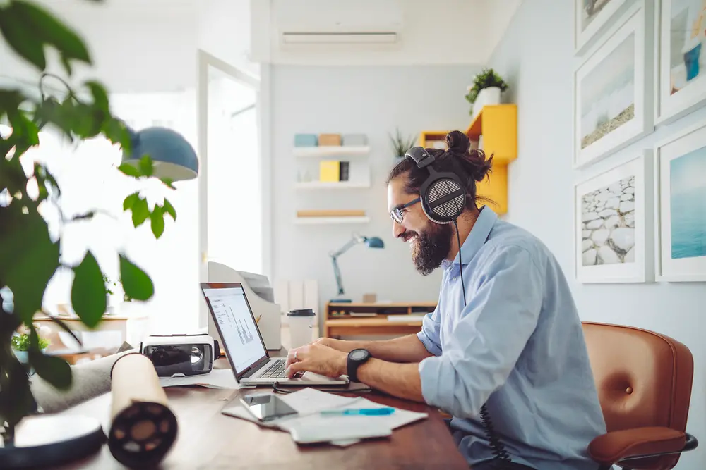 Hombre con auriculares sentado en un escritorio trabajando