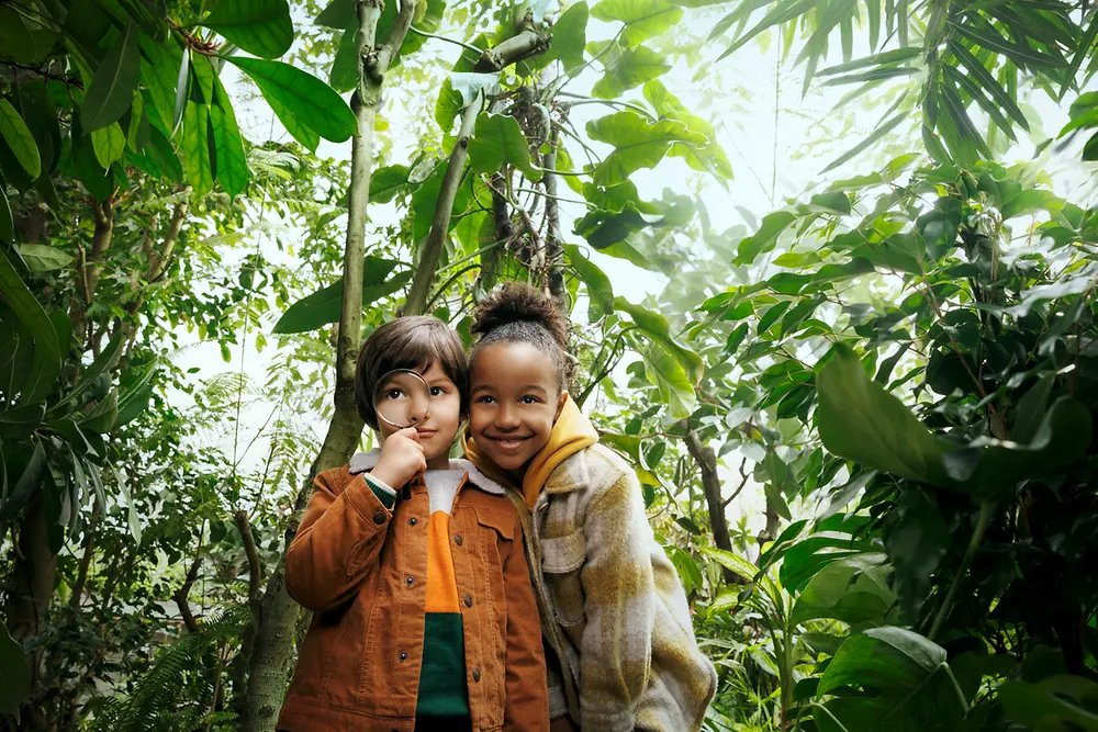 Dos niños en mitad de un bosque.